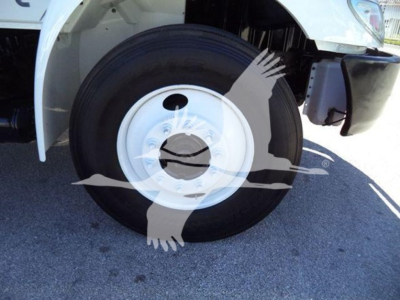 Truck front wheel and fender with white steel wheel and black tire; partial cab visible.