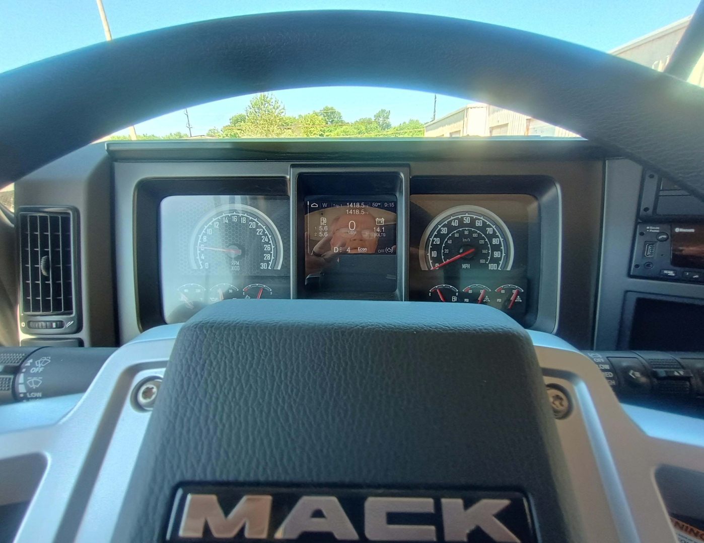 Dashboard view of a 2027 Mack GR84F with steering wheel and instrument cluster visible.