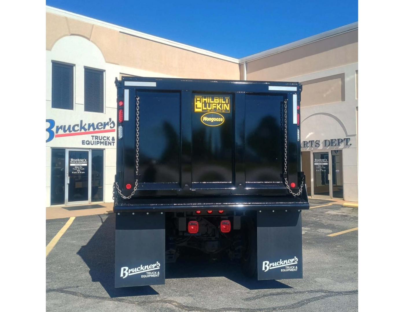 Dump truck dump bed with CHIEFTAIN trademark chain hooks and rear view showing company decals