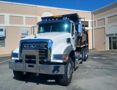Mack GR84F dump truck front view showing grille, bumper, and cab with chrome accents.