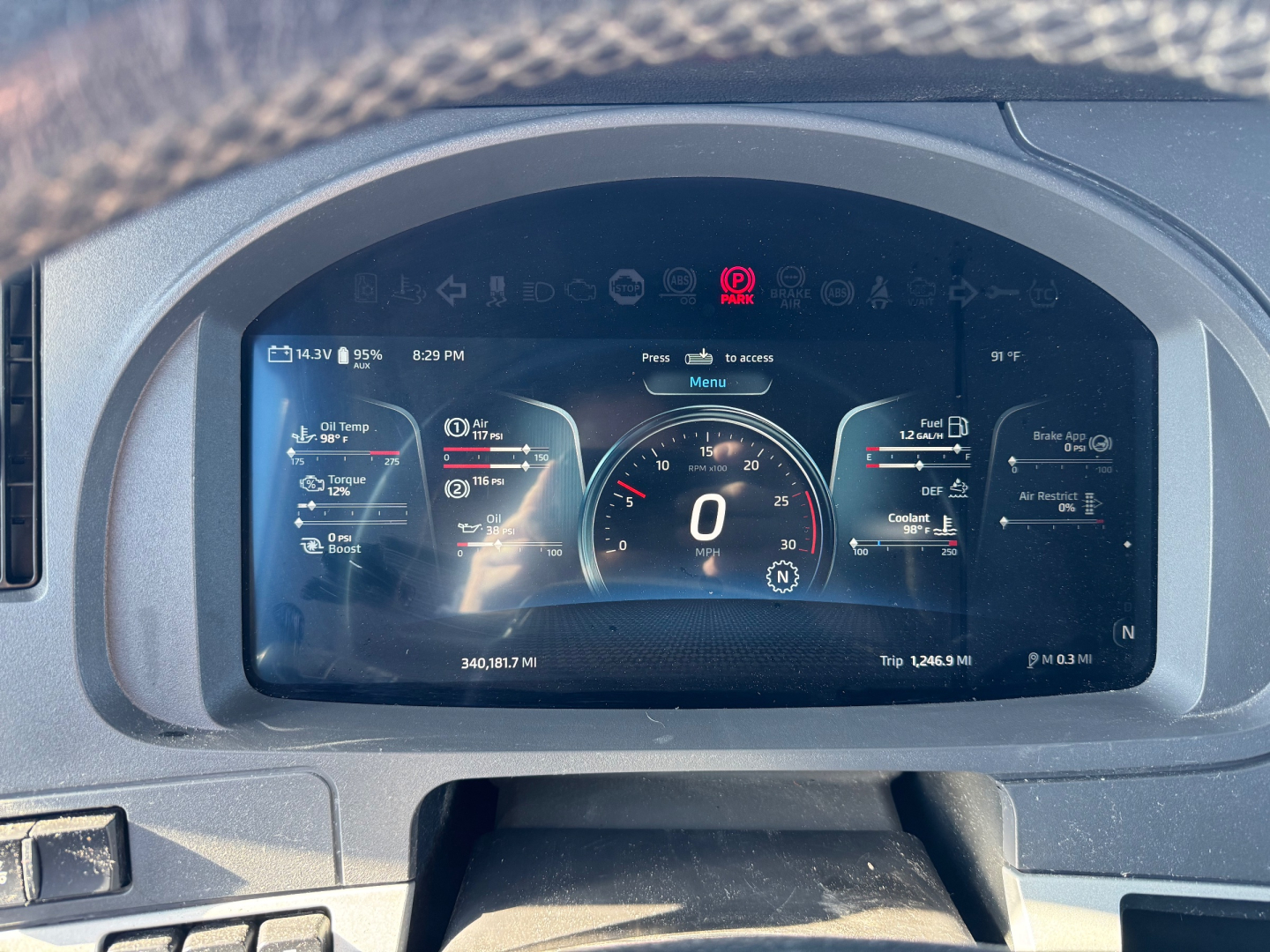 Kenworth T680 instrument cluster display showing digital gauges, warning icons, and vehicle status readout.