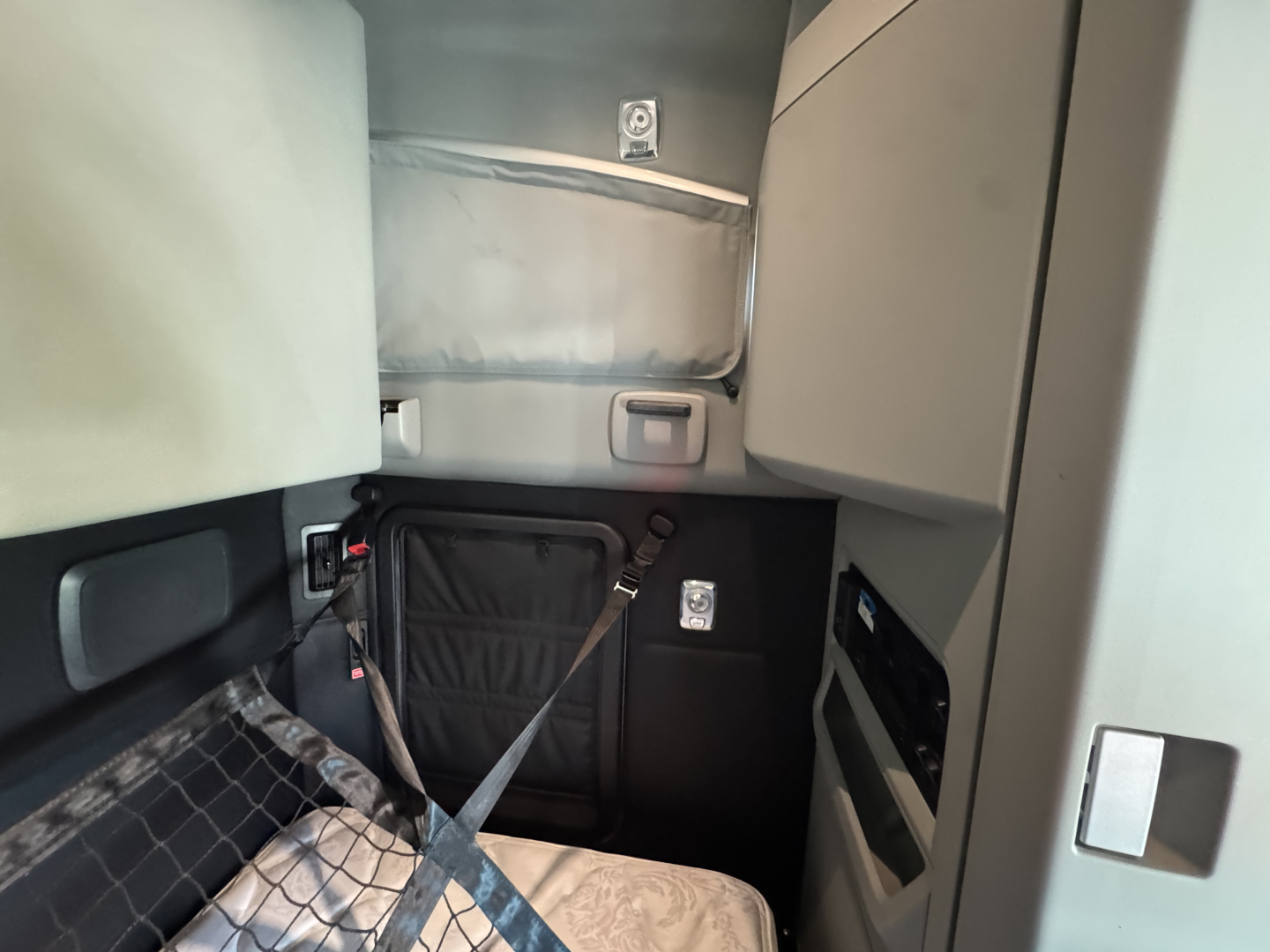 Kenworth T680 sleeper cab interior showing seat area and seat belt in view.