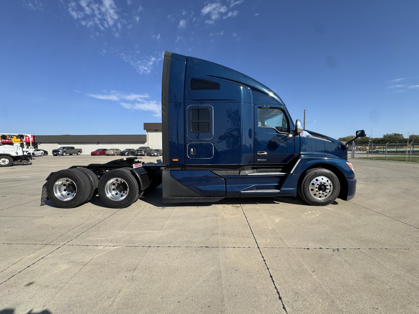 Kenworth T680 tractor side view showing sleeper cab and dual rear axles with chrome wheels