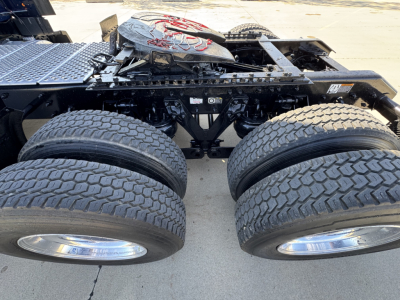 Kenworth T680 chassis with dual rear axles and dual tires in view, showing wheel rims, frame, and fifth-wheel mounting area.