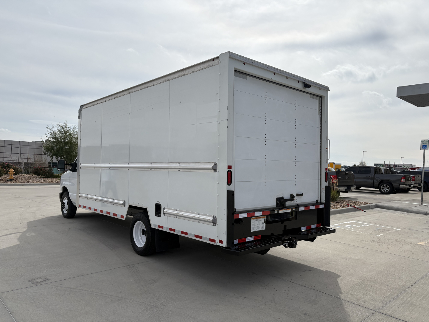 Ford E-350 box truck rear view showing cargo area with closed rear doors and bumper with reflectors.