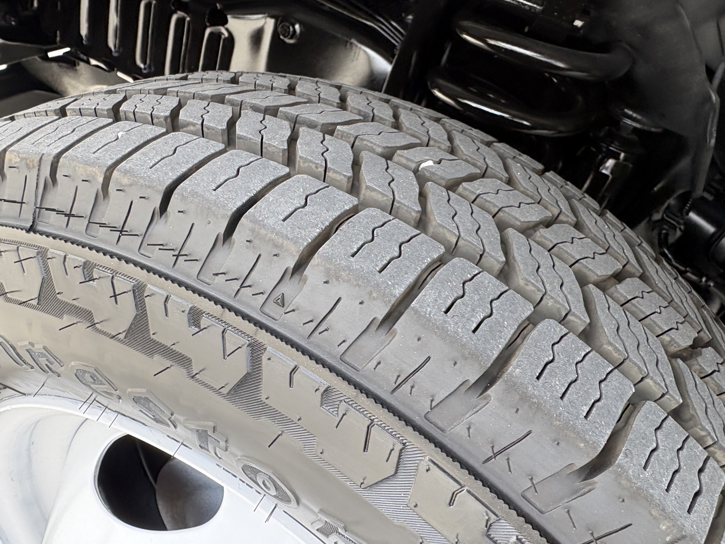 Tire close-up on Ford E350 chassis showing tread pattern and wheel well components.