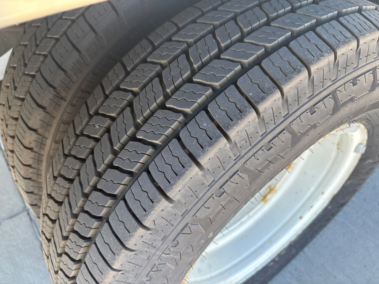 Tire tread close-up on Ford E350 wheel showing tread pattern and rim edge.