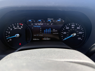 Ford E-350 dashboard showing instrument cluster with tachometer, speedometer, and LCD display. Vehicle information and fuel history visible.