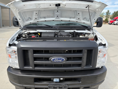 Front view of a 2022 Ford E350 with its hood open, showing the engine bay, Ford grille, and front bumper.