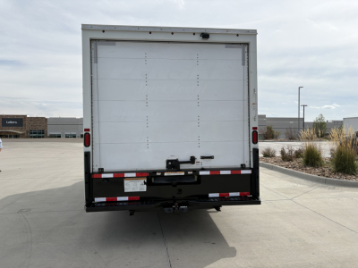 Rear view of a Ford E-350 box truck with a white cargo door, taillights, and a black bumper. There is no visible branding text on the back besides vehicle hardware.