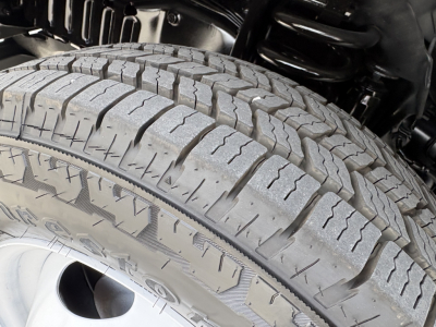 Tire close-up on Ford E350 chassis showing tread pattern and wheel well components.