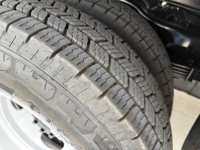 Ford E-350 wheel tire close-up showing tread pattern and sidewall details.