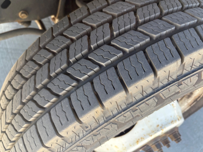 Ford E350 wheel tire close-up showing tread pattern and part of wheel well.