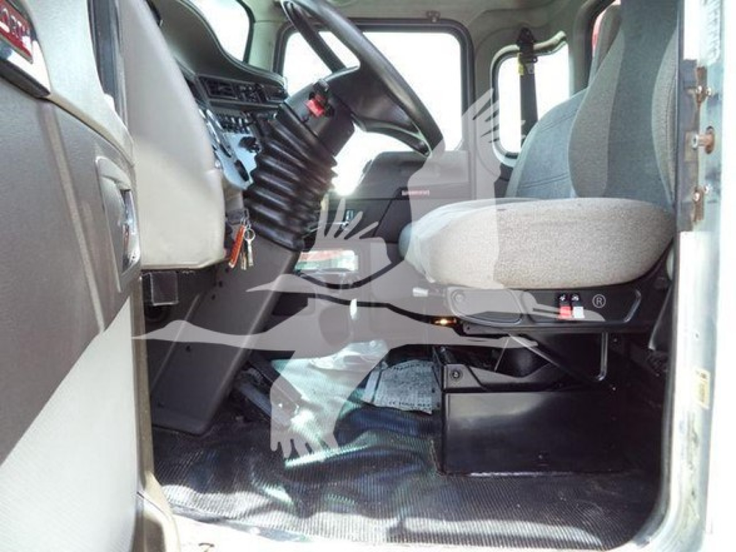 Cab interior of a 2019 Kenworth T270 rollback truck showing driver seat, steering column, and dashboard shelves.