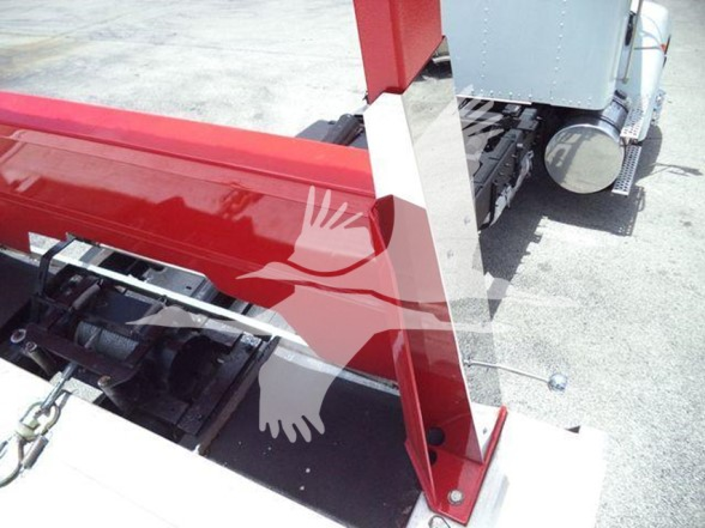 Kenworth rollback truck bay showing hydraulic system components and red body panel