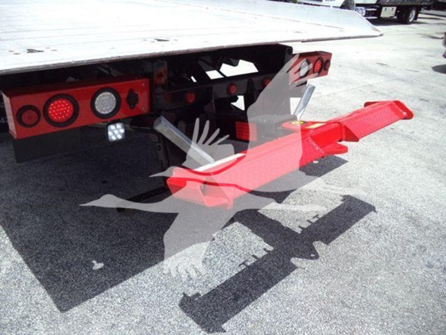 Kenworth T270 rollback truck rear view showing bright red tow bar and bumper skid, bumper lights, and hitch mechanism.