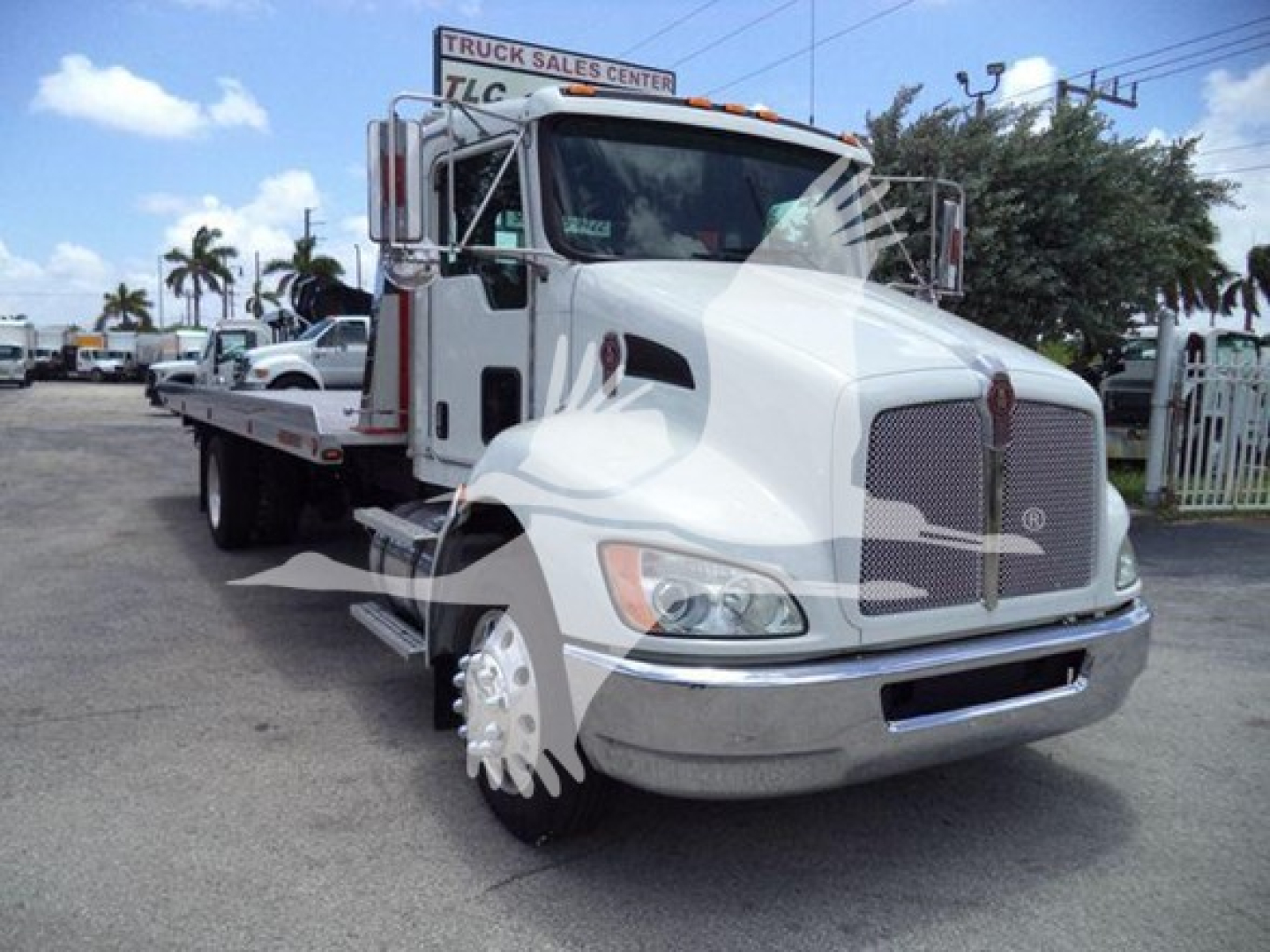 Kenworth T270 rollback truck on lot showing front grille, bumper, and flatbed with chrome mirrors.