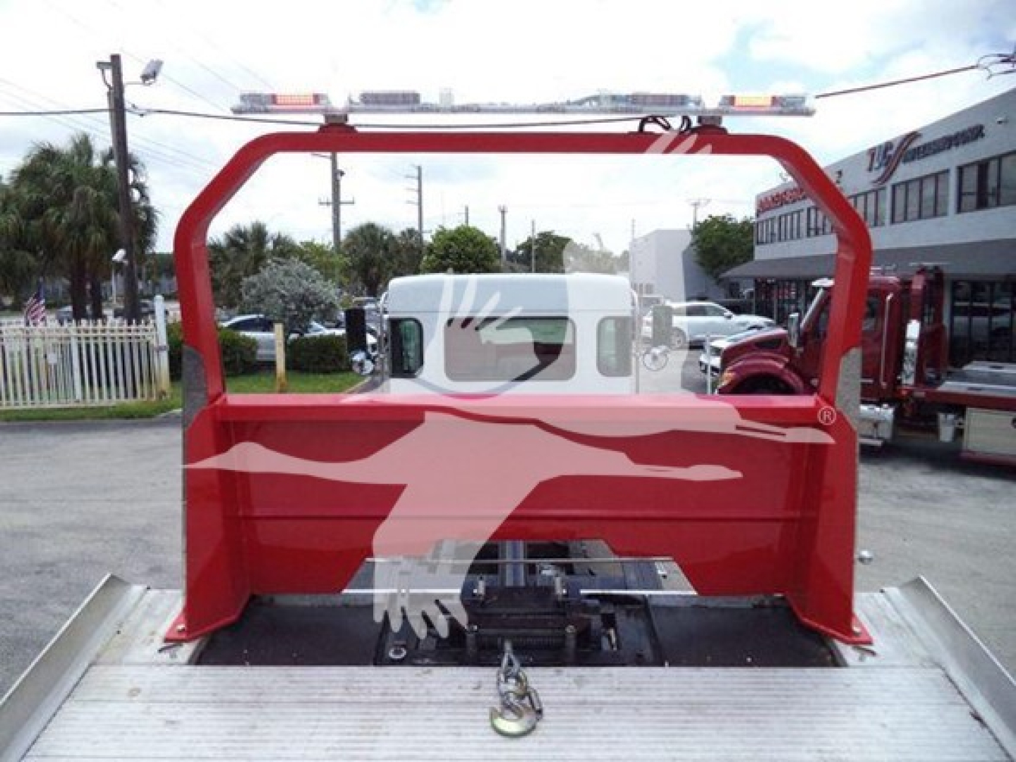 Truck bed with red mounting rack in a rollback setup, view from rear showing frame and attachment hardware.