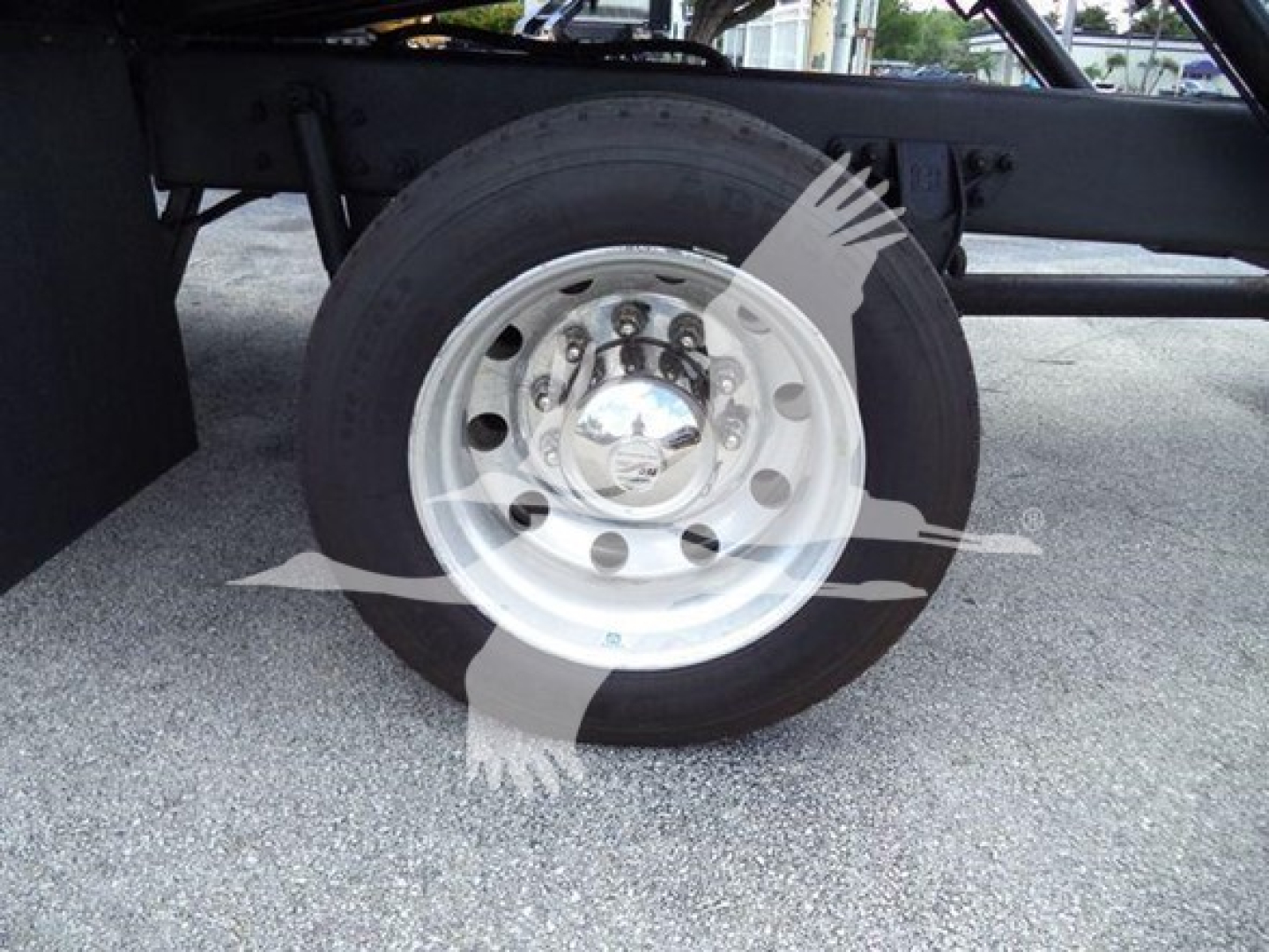 Wheel and tire of a Kenworth truck side view showing polished aluminum rim and hub area