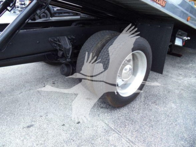Truck chassis and front wheel of a 2019 Kenworth T270 rollback showing dual wheels and undercarriage components.