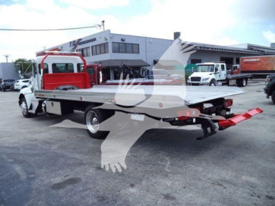 Kenworth T270 rollback with flatbed, red cab area behind the cab, rear yellow warning stripe, equipment trailer attached.