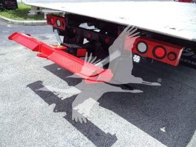 Rear of a rollback truck with a red loading ramp and tail lights visible