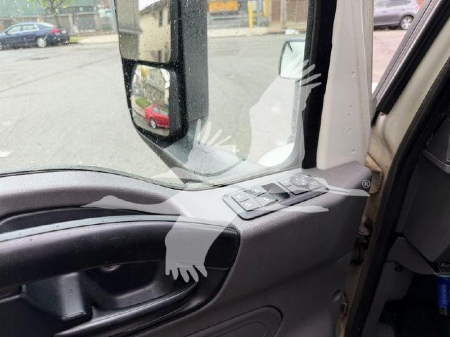 Truck cab interior showing door panel and window controls, front seating area with side mirror visible.