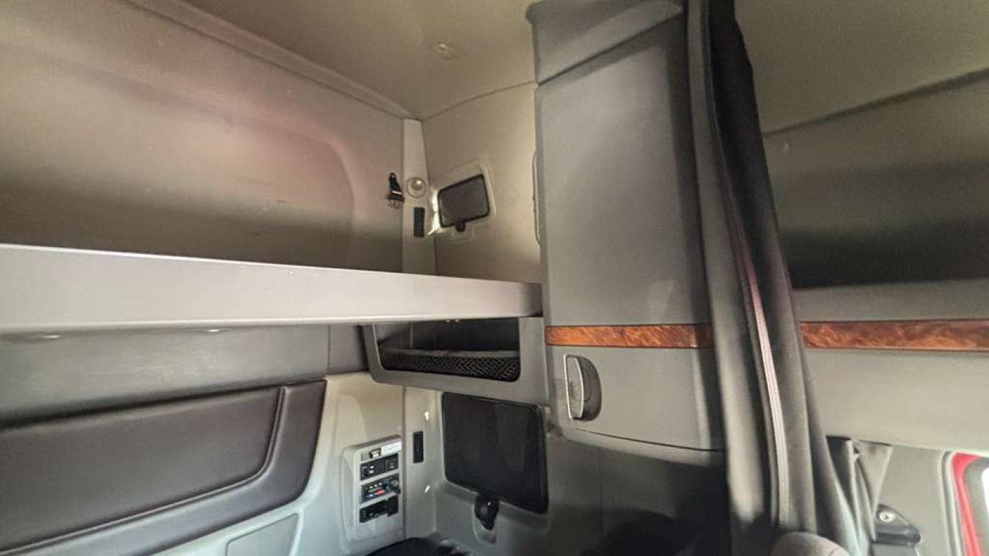 Interior sleeper cab storage area with overhead cabinet and mounted TV/monitor bracket in a 2022 International LT625 truck.
