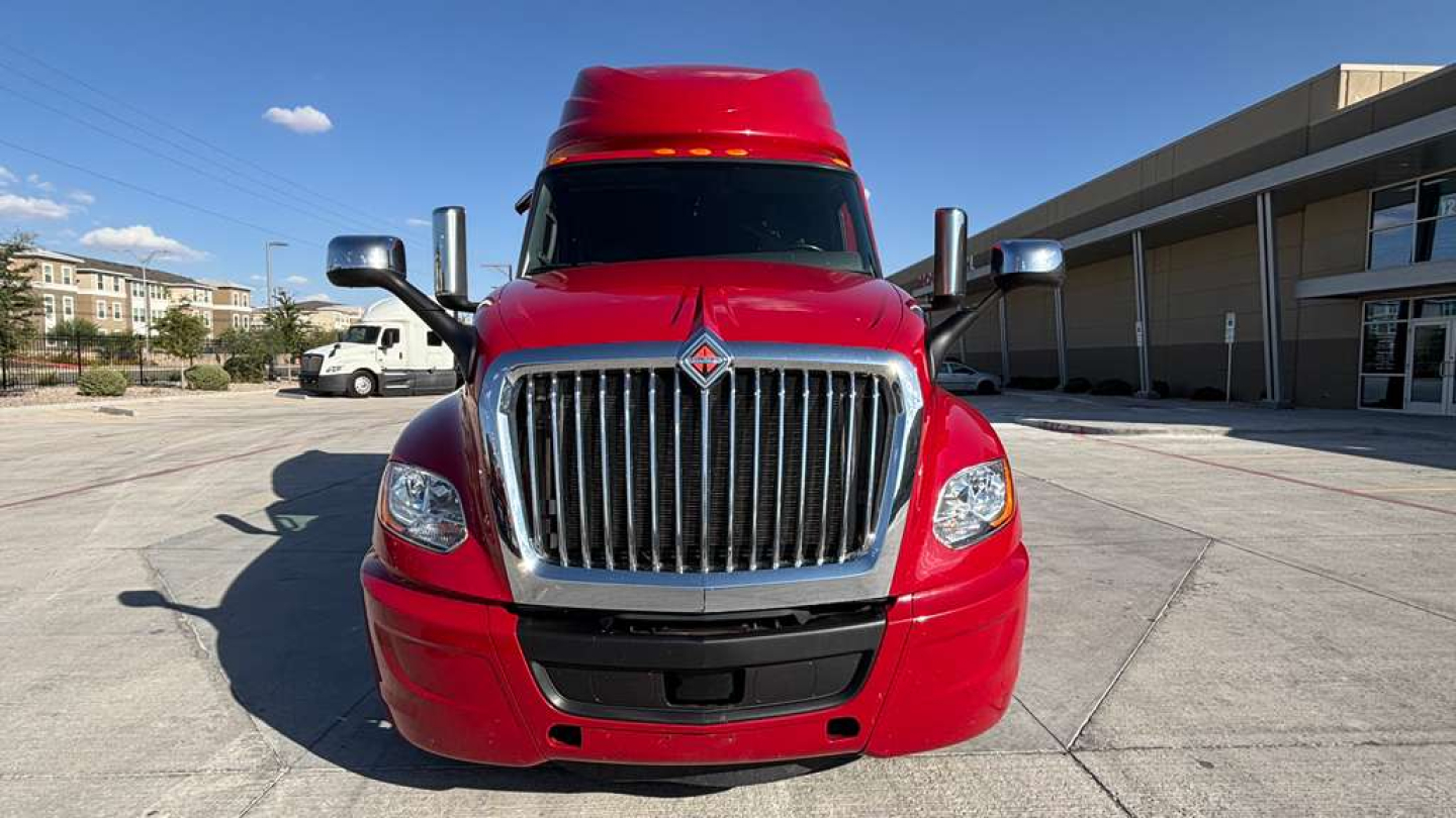 Truck front view of a red 2022 International LT625 with prominent chrome grille and IH emblem, headlights, and aerodynamic hood.