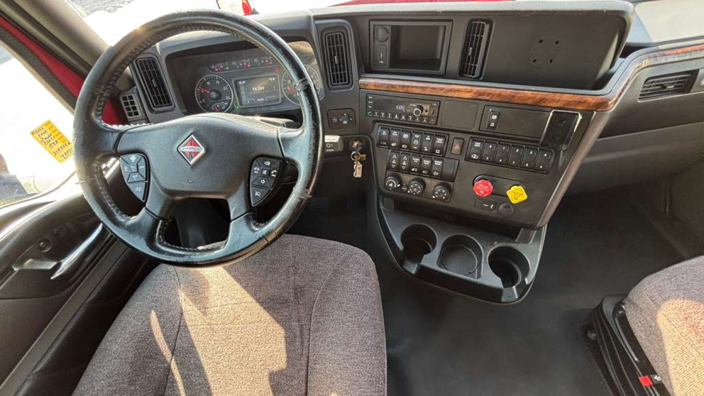 Interior cockpit of a 2022 International LT625 truck with steering wheel, dashboard, and center console showing numerous controls and gauges.