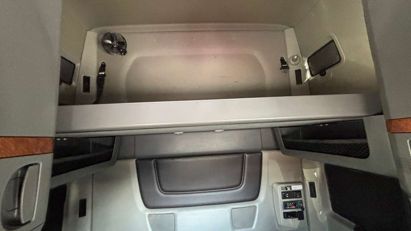 Interior cab storage area of a 2022 International LT625 sleeper truck showing overhead bunk space and control panel to the right.