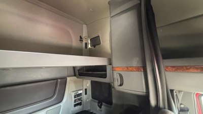 Interior sleeper cab storage area with overhead cabinet and mounted TV/monitor bracket in a 2022 International LT625 truck.