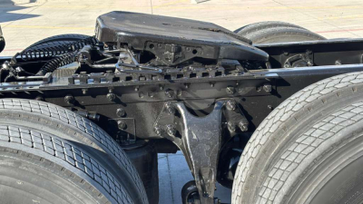 Trucks chassis section showing spring suspension and battery box area with dual rear wheels on a 2022 International LT625 truck