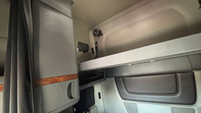 Trucker cabin interior view of a 2022 International LT625 sleeper cab showing bunk area and cabinetry.
