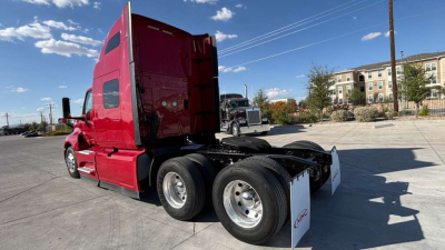 Side/back view of a red 2022 International LT625 conventional sleeper truck showing rear chassis and dual rear axles.