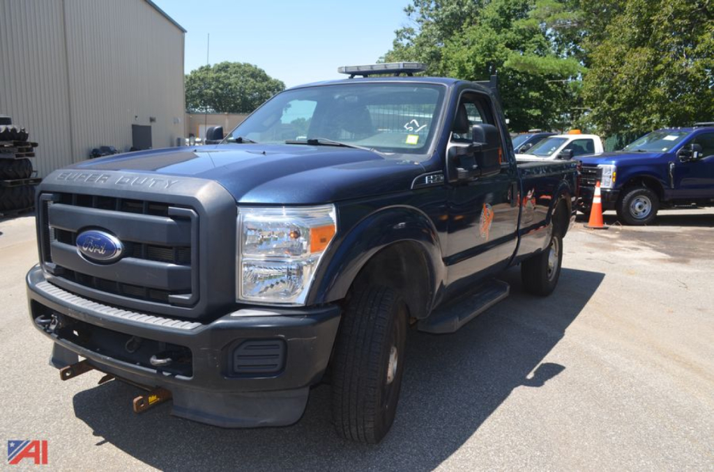 Ford F-250 Super Duty pickup truck in dark blue, front-left view, with orange cones in background.