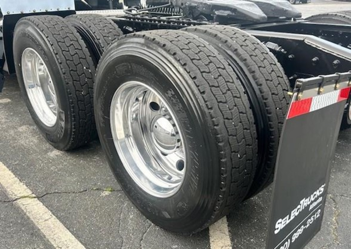 Freightliner Cascadia 126 wheel trio showing dual rear axles with chrome rims and tire treads.