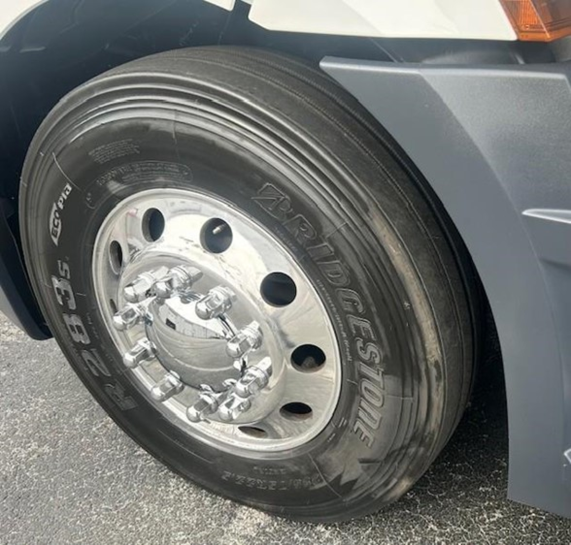 Rear front tire and wheel of a Freightliner Cascadia 126 showing Goodyear Tires with hub and wheel nuts.