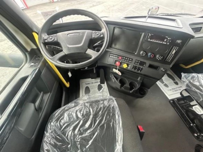 Cab interior of a Freightliner Cascadia 126 truck showing steering wheel, dashboard, and center console with touchscreen display and control buttons.