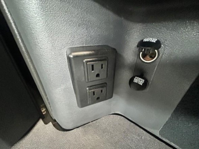 Interior view showing dual power outlets and 12V DC cigarette lighter sockets on Freightliner Cascadia dash panel.