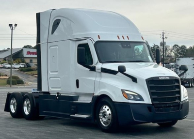 Freightliner Cascadia 126 tractor in a parking lot, front-right angle.