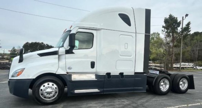 Truck cab showing Freightliner Cascadia 126 sleeper with white exterior and dark lower trim, side mirrors, and 6-wheel rear assembly.