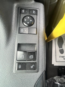 Truck interior control panel in view showing window/mirror adjustment pad and lock/window switches on door panel.