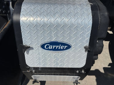 Kenworth T680 air intake/under-hood area with Diamond plate cover showing Carrier logo on vertical exhaust/air reservoir area