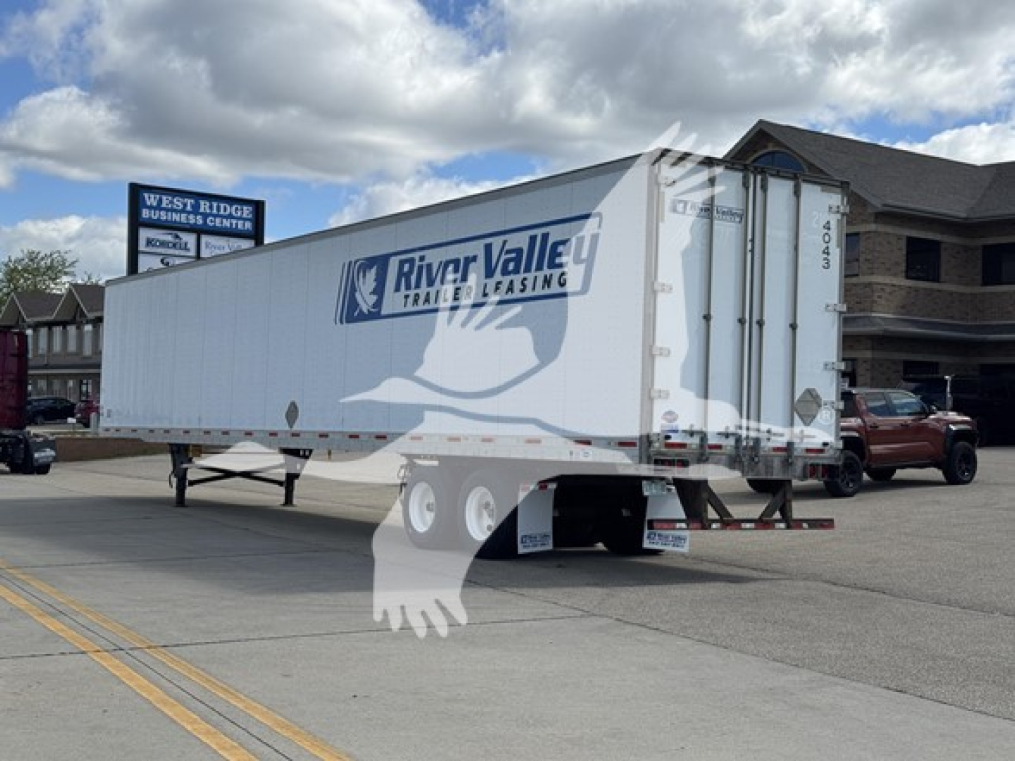 Trailer showing River Valley trailer leasing logo on a white box semi-trailer connected to a red pickup truck.