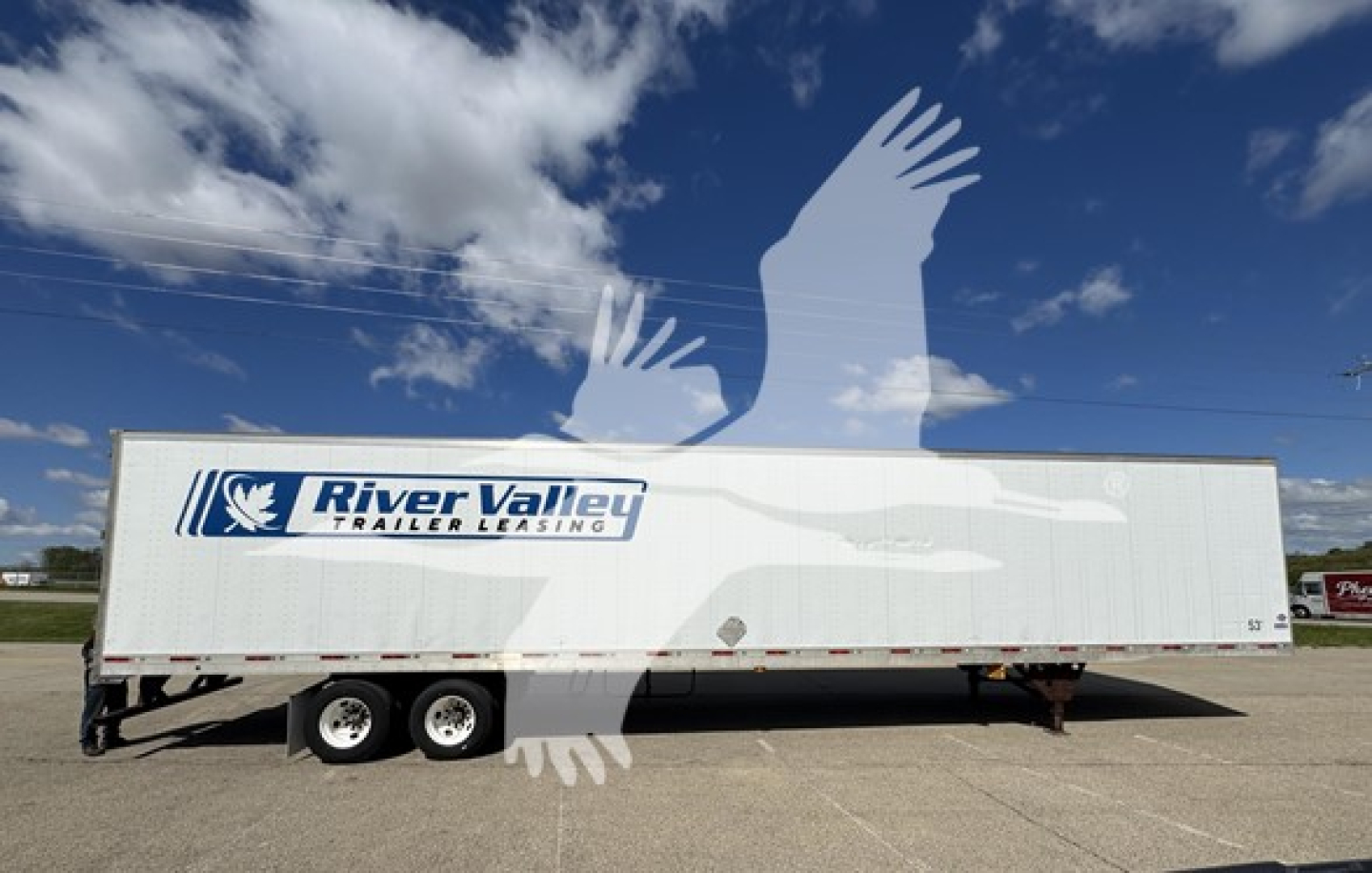 Trailer side showing River Valley Trailer Leasing logo and text on a white utility trailer in a parking lot.