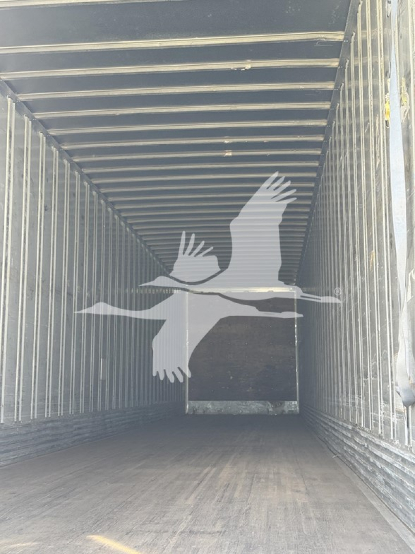 Interior view of a used Utility 4000Dx trailer cargo space with vertical walls and wooden floor.