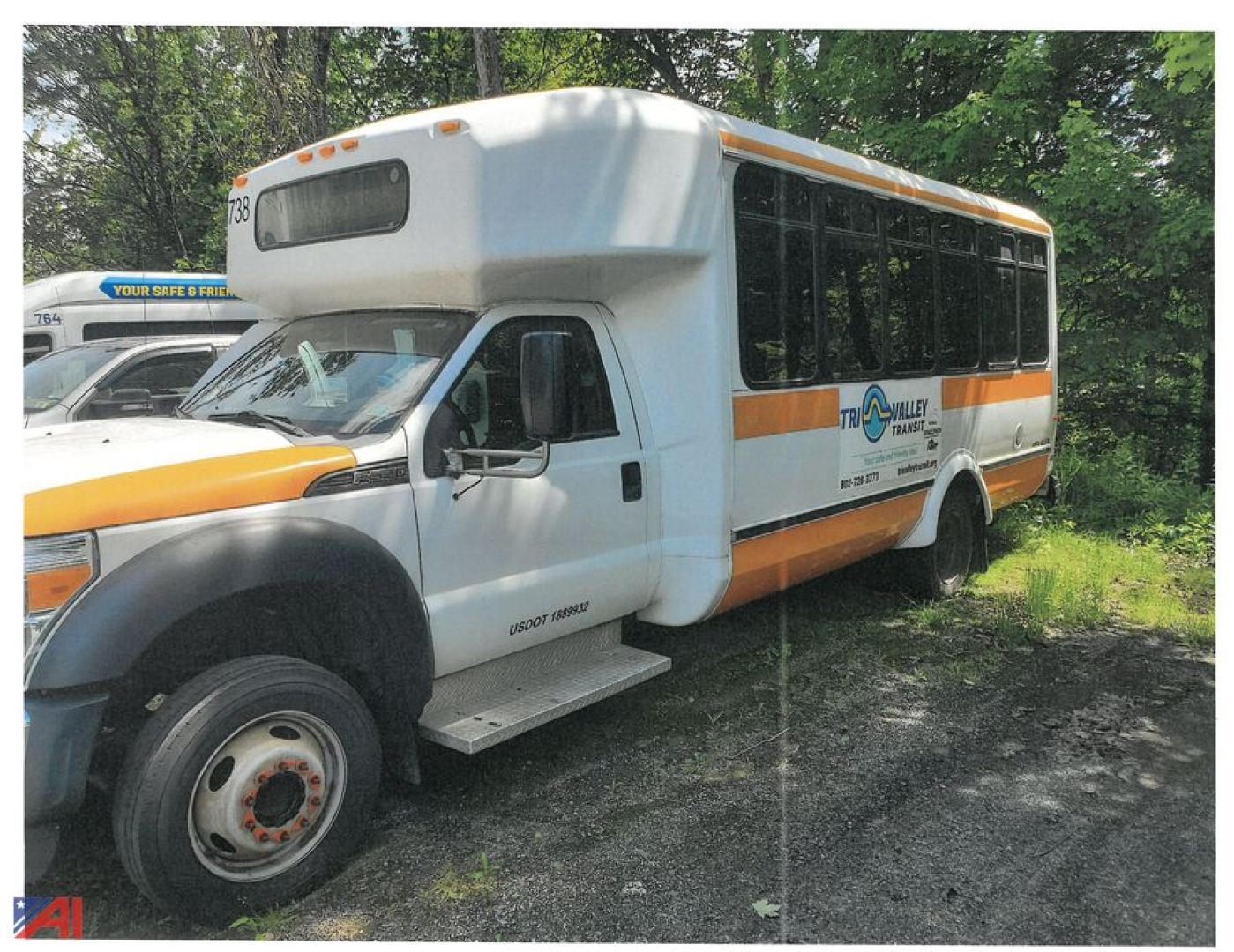 Ford F-550/SD bus chassis showing side view with orange stripe and Transit logo, front wheel, and raised roof.