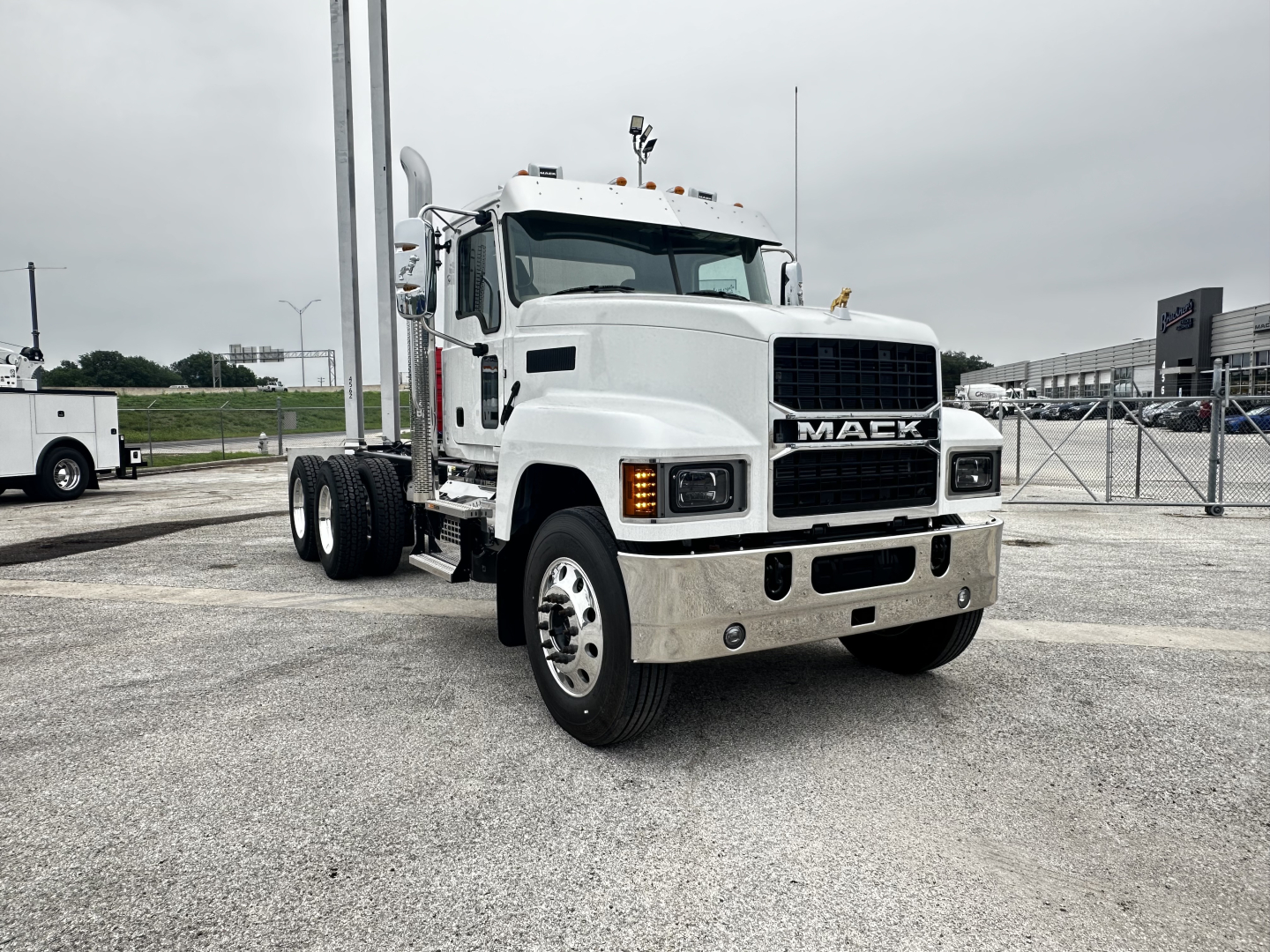 Mack PI64 cab and chassis truck front view showing grille with 'MACK' emblem, large bumper, and dual rear axles.