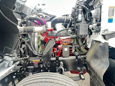 Engine bay of a 2026 Mack PI64 cab and chassis showing exposed engine components and hoses.
